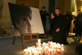 Un prêtre prie devant le portrait de l'indépendantiste corse Yvan Colonna, tué par un co-détenu en prison, à l'entrée de la cathédrale d'Ajaccio, le 22 mars 2022