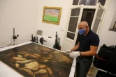 Gaby Maamary, un artiste libanais restaure dans son atelier à Beyrouth le 17 septembre 2020 des oeuvres endommagées dont celle de la peintre italienne Elena Recco, abimée par des éclats de verre lors de l'explosion du port de Beyrouth