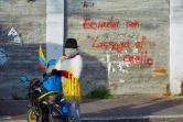 Une femme indigène se tient près d'une inscription murale disant "L'Equateur avec la corde au cou", dans un jeu de mots avec le nom du président Guillermo Lasso, à Quito, le 21 juin 2022