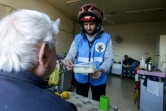 Un membre du club de motards "Hope Bikers Syria" distribue des repas pour l'iftar à des personnes dans le besoin, pendant le ramadan, le 25 mars 2024 à Damas, en Syrie