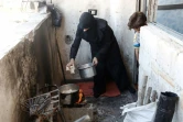 Une syrienne cuisine des champignons, cultivés localement par la Fondation Adala dans la ville assiégée de Douma, à l'est de Damas, le 3 août 2017