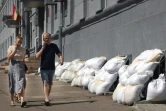 Des habitants passent devant la mairie dont les fenêtres du sous-sol sont protégées par des sacs de sable, à Koursk, le 16 août 2024 en Russie