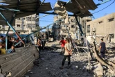 Des Palestiniens inspectent les décombres de l'école Jaouni à Nousseirat dans le centre de Gaza, abritant des déplacés et gérée par l'ONU, où l'armée israélienne a dit avoir visé des "terroristes" le 6 juillet 2024