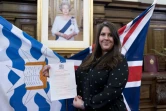 Une femme, nouvelle citoyenne britannique, montre son certificat de naturalisation, après une cérémonie d'allégeance à la reine Elizabeth II, le 5 février 2018 à Islington, dans le nord de Londres