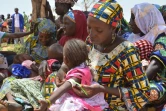 Au Niger, une mère utilise un périmètre brachial (PB), un brassard tricolore, qui sert à mesurer l'épaisseur du bras et détecter la malnutrition, dans le village de Barago (sud), le 14 juillet 2016 