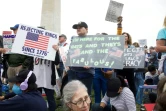 Des manifestants brandissent des pancartes sur le National Mall, à Washington, le 5 avril 2025