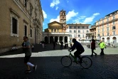 Un homme fait du vélo et un autre court, sur une place de Rome, le 3 mai 2020