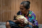 Une femme toraja tient le corps exhumé de son bébé décédé en 1988, lors du rituel traditionnel du Manene à Pangala, dans le sud de l'île des Célèbes, le 27 août 2024 en Indonésie