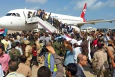 Une foule de Yéménites accueillant les membres du nouveau gouvernement d'union à leur arrivée à l'aéroport d'Aden le 30 décembre 2020, peu de temps avant plusieurs explosions ayant secoué l'aéroport faisant des morts et ds blessés