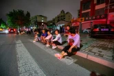 Des habitants assis dans la rue après un séisme de magnitude 5,4, le 6 août 2023 dans la localité de Dezhou dans l'est de la Chine 
