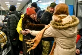 Des habitants aident une vieille femme fuyant Marioupol, arrivée à Zaporojie, dans le sud-est de l'Ukraine, le 22 mars 2022