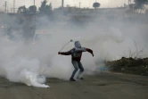 Un Palestinien lance une grenade lacrymogène sur des forces israéliennes près de la colonie israélienne de Beit El, en Cisjordanie occupée, le 23 janvier 2018
