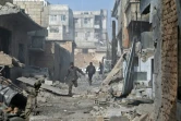 Un Syrien court à travers les rues de Mesraba, près de Damas, le 27 novembre 2017