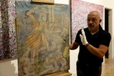 Gaby Maamary, un artiste libanais examine dans son atelier à Beyrouth le 17 septembre 2020 une oeuvre du 19è siècle endommagée par l'explosion du port de la capitale libanaise