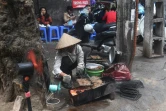 Une vendeuse de rue prépare un "bun cha", une soupe à base de nouilles et de porc grillé, en janvier 2018 à Hanoï, au Vietnam
