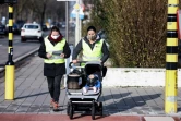 Des volontaires se promènent avec Claire dans sa poussette, une poupée équipée de capteurs pour mesurer la pollution de l'air, à Anvers (Belgique) le 25 janvier 2021.