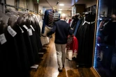 Un employé déplace dans les vestiaires deux vestes des costumes du ballet "Le Rouge et le Noir" du chorégraphe français Pierre Lacotte, le 2 avril 2021 à l'atelier de couture de l'Opéra de Paris