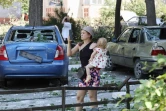 Une femme prend une photo avec son portable d'un bâtiment détruit après avoir été touchée par une frappe de missile dans la ville ukrainienne de Serhiivka, près d'Odessa, tuant au moins 18 personnes et en blessant 30, le 1er juillet 2022