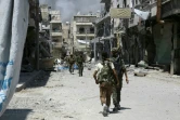 Des membres des Forces démocratiques syriennes (SDF) patrouillent dans la ville de Minbej (nord de la Syrie) le 7 août 2016 pour traquer les jihadistes