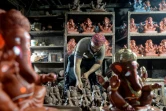 Le potier Yusuf Zakaria Galwani inspecte le 15 août 2020 dans son atelier du bidonville de Dharavi, à Bombay, une statuette en terre cuite du dieu hindou Ganesh