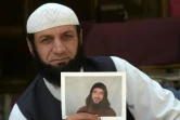 L'Afghan Roman Khan montre une photo de son frère, Asadullah Haroon, l'un des deux derniers détenus afghans dans la prison américaine de Guantanamo, le 25 septembre 2020 dans un camp de réfugiés près de Peshawar, au Pakistan