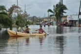 Des habitants utilisent un kayak pour se déplacer dans leur rue inondée, à Juana Matos, sur lîle de Porto Rico, le 21 septembre 2017 après le passage de l'ouragan Maria