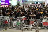 Des manifestants pro-démocratie bloquent l'entrée des terminaux à l'aéroport de Hong Kong, le 13 août 2019
