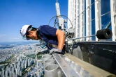 Seo Seung-ho, laveur des vitres du plus haut gratte-ciel de Séoul, le Lotte World Tower, sur une "nacelle" suspendue par des câbles au 125e étage du bâtiment, le 4 juin 2024 à Séoul, en Corée du Sud