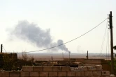 De la fumée s'échappe d'habitations après un raid aérien mené par Damas sur le village syrien de Mregel, près d'Alep, le 9 octobre 2016