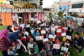 Les enfants montrent leurs dessins à la bibliothèque de rue de Kolong, le 10 février 2019 à Jakarta, en Indonésie