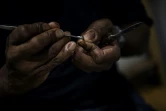 Les mains du plumassier Eric Charles-Donatien qui travaille sur une création dans son atelier à Paris, le 20 juin 2018
