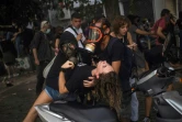 Un manifestant aide une jeune femme après des tirs de gaz lacrymogène par la police à Athènes le 7 octobre 2020