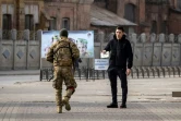 Un membre des forces ukrainiennes contrôle un passant après un bombardement russe à Kharkiv, le 31 mars 2022.