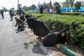 Des femmes et des soldats cherchant à s'abriter lors d'un attentat commis le 22 septembre 2018 pendant un défilé militaire dans la ville iranienne d'Ahvaz