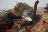 Une femme cuisine en plein air dans un camps de déplacés, le 17 décembre 2021 dans le nord-ouest de la Syrie