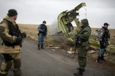 Des soldats pro-Russes et des enquêteurs sur les lieux du crash du vol MH17, près de Grabove, le 11 novembre 2014, dans l'est de l'Ukraine 