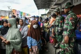 Des habitants de Palu, aux Célèbes, font la queue le 7 octobre 2018 pour recevoir de l'aide après le séisme suivi d'un tsunami qui a ravagé l'île.