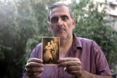 Gili Grunbaum, 60 ans, d'origine tunisienne, pose avec un portrait de ses parents adoptifs le 6 juillet 2016 à Ramat Gan près de Tel Aviv