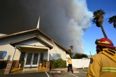 Des pompiers aspergent une église avec un produit ignifuge, lors d'un incendie à Castaic, près de Los Angeles, le 22 janvier 2025