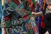 La créatrice de mode irakienne Hana Sadiq montre l'une de ses robes ornées de poèmes arabes, le 31 mars 2022 à Amman, en Jordanie