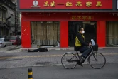 Un cycliste passe à côté du corps d'un homme mort dans la rue à Wuhan, le 30 janvier 2020 en Chine