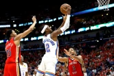 Shai Gilgeous-Alexander (c.), le meneur du Thunder d'Oklahoma City, tire devant CJ McCollum (d.), l'arrière des Pelicans de La Nouvelle-Orléans pendant le troisième match du premier tour des play-offs NBA, le 27 avril 2024, à La Nouvelle-Orléans