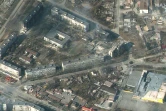 Cette photo satellite prise par la société Maxar satelitte le 18 mars 2022 montre des bâtiments d'habitation et des commerces de Marioupol (Ukraine) en flammes et très endommagés