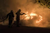 Un pompier lutte contre les flammes d'une voiture incendiée dans le quartier Malakoff de Nantes, le 4 juillet 2018