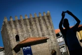 Un touriste prend une photo près des tours Pitoes à Porto, le 25 juillet 2016