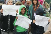 De jeunes migrants posent avec des affichettes réclamant leur départ pour le Royaume-Uni, le 26 octobre 2016, dans la "Jungle" de Calais