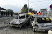 Des gendarmes près de voitures brûlées pendant les émeutes à Moirans près de Grenoble le 21 octobre 2015