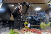 Le vendeur de street food Habib el-Bey prépare des sandwiches dans son van garé le long de l'avenue Habib Bourguiba le 2 juillet 2022, à Tunis
