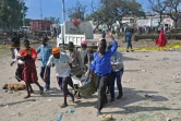 Des gens transportent le corps d'une victime de l'attentat-suicide au camion piégé qui a fait plus de 20 morts près de l'entrée du port de Mogadiscio