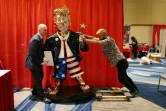 Matt Braynard (G) aide l'artiste Tommy Zegan (D) à installer sa statue de Donald Trump, à Orlando, en Floride le 27 février 2021